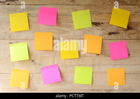 Vuoto colorato sticky notes su legno bulletin board, pronto per il messaggio Foto Stock