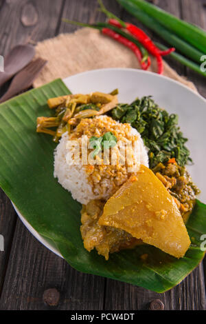 Nasi padang servita con carni bovine curry di tendine, jackfruit giovani e foglie di manioca con sambal hijau o salsa piccante Foto Stock