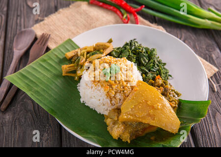 Nasi padang servita con carni bovine curry di tendine, jackfruit giovani e foglie di manioca con sambal hijau o salsa piccante Foto Stock