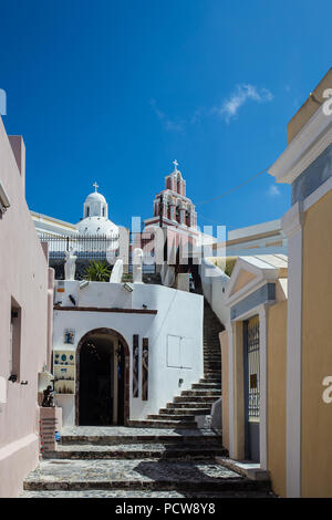 Stupenda vista della strada in bianco della città murata di Fira a Santorini, Grecia, con greca chiese ortodosse in background su entrambi i lati Foto Stock