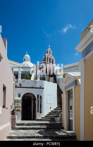 Stupenda vista della strada in bianco della città murata di Fira a Santorini, Grecia, con greca chiese ortodosse in background su entrambi i lati Foto Stock