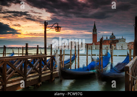 Parcheggiato gondole a Venezia con l'isola di San Giorgio Maggiore in background Foto Stock