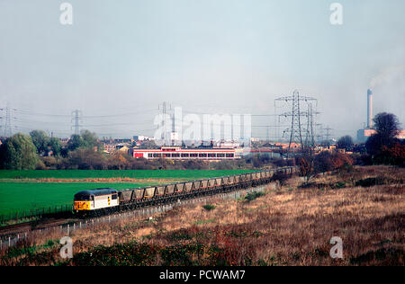 Una classe 56 locomotiva diesel numero 56071, dipinta di fresco in Raifreight triple grigio carbone trainload livrea lavorando un vuoto di MGR carbone treno Crayford. 11 novembre 1993. Foto Stock