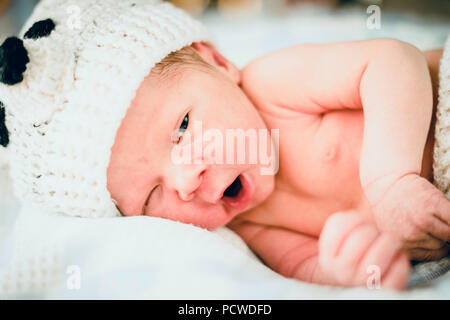 Il neonato bambino vestito di bear-come vestiti leggeri Foto Stock