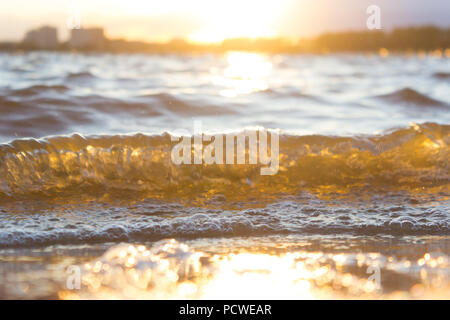 Immagine sfocata di onde in una calda luce del sole Foto Stock