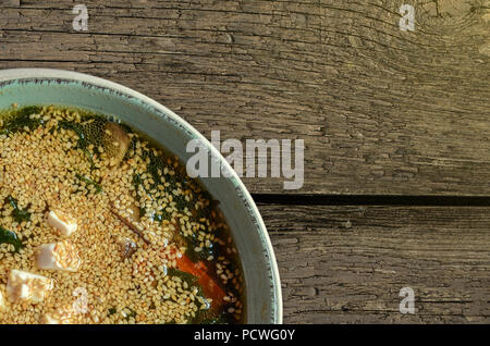 Gustosa zuppa di pesce con i semi di sesamo nel verde della piastra di porcellana su sfondo grigio. La cucina giapponese. Foto Stock