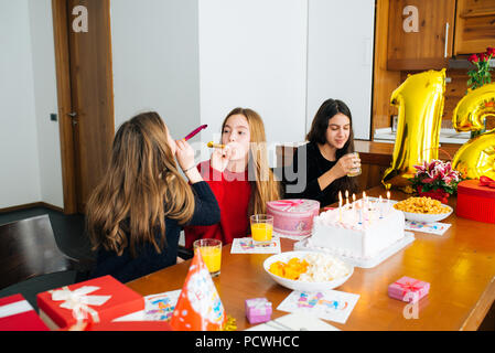 Gruppo di bambini festeggiare il compleanno insieme e soffiando nei fischietti Foto Stock