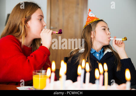 Gruppo di bambini festeggiare il compleanno insieme e soffiando nei fischietti Foto Stock