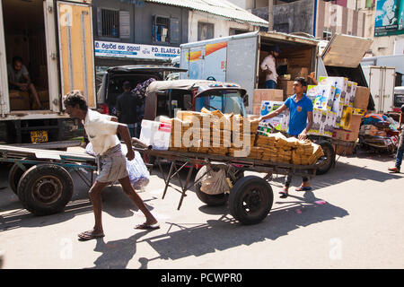 COLOMBO SRI LANKA - Dic 24, 2016: Il portiere al mercato Pettah andando contro la folla con carrello completo sul dicembre 24, 2016 in Colombo. Lo Sri Lanka. Foto Stock