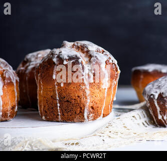 Dolci da forno per Pasqua e versata glassa, dietro lo sfondo nero Foto Stock