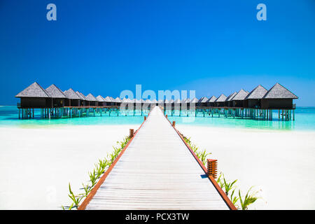 Bellissimo resort tropicale con spiaggia wihte e acqua turchese per rilassarsi su Olhuveli island, Maldive. Spiaggia di sabbia bianca con una barriera corallina. Best Beach Foto Stock