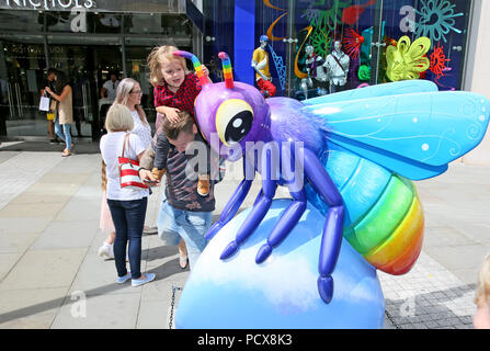 Manchester, Regno Unito, 3 agosto 2018. Un giovane di esplorare un gigante Bee. Il Manchester City Council e selvaggio circa arte stanno portando la comunità insieme con 'Bee nella città' che vede oltre a 1oo Bee Gigante sculture disegnate individualmente e disposto intorno alla città. Vi è un'applicazione interattiva per famiglie da utilizzare per trovare le api e sembra attrarre le famiglie a tutti gli angoli della città.(consenso dato) Manchester, 4° agosto 2018 (C)Barbara Cook/Alamy Live News Foto Stock