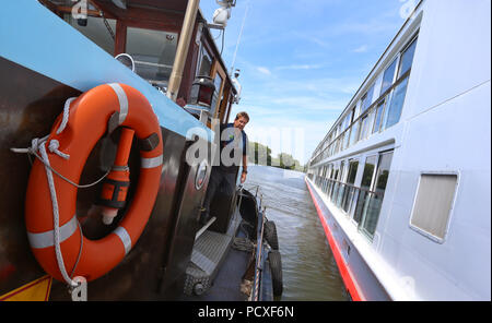 Würzburg, Germania. 04 Luglio, 2018. Operations Manager Klaus Philipp docks il suo bunker nave nei pressi di una nave da crociera sul fiume Main. Credito: Karl-Josef Hildenbrand/dpa/Alamy Live News Foto Stock