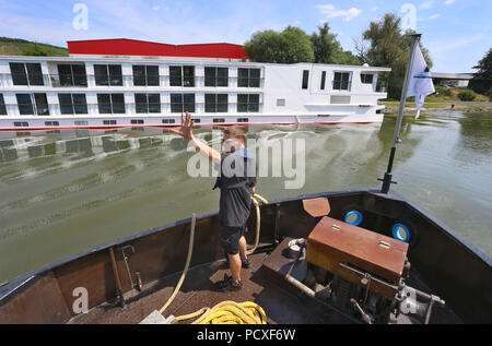 Würzburg, Germania. 04 Luglio, 2018. Shipman Michl Rueckauer docks il suo bunker nave nei pressi di una nave da crociera sul fiume Main. Credito: Karl-Josef Hildenbrand/dpa/Alamy Live News Foto Stock