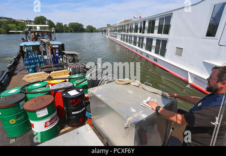 Würzburg, Germania. 04 Luglio, 2018. Nave uomo Matthias Hemmelmann docks la sua nave bunker accanto a una nave da crociera sul fiume Main. Credito: Karl-Josef Hildenbrand/dpa/Alamy Live News Foto Stock