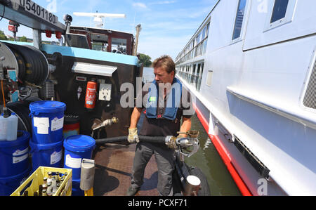 Würzburg, Germania. 04 Luglio, 2018. Operations Manager Klaus Philipp docks il suo bunker nave nei pressi di una nave da crociera sul fiume Main. Credito: Karl-Josef Hildenbrand/dpa/Alamy Live News Foto Stock