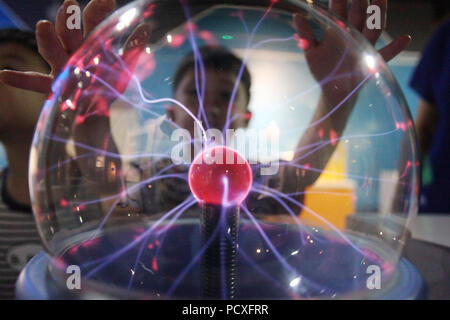 Yangzhou, cinese della provincia di Jiangsu. Il 4° agosto 2018. Un bambino guarda un plasma magic ball a Yangzhou il Museo delle Scienze e della tecnologia in Yangzhou, est cinese della provincia di Jiangsu, e il Agosto 4, 2018. Bambini arricchito le loro vacanze estive qui mediante l'apprendimento di conoscenze scientifiche e tecnologiche. Credito: Meng Delong/Xinhua/Alamy Live News Foto Stock