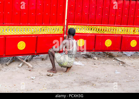 Pondicherry, PUDUCHERRY, Tamil Nadu, India - MARZO CIRCA, 2018. Uomo maschio lavoratore è dipinto un grande cancello esterno in rosso e in giallo. Foto Stock