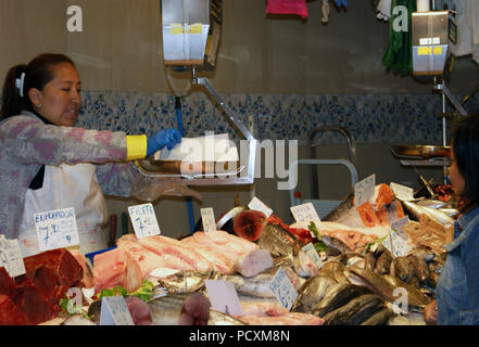 Donna del peso di un pezzo di pesce fresco del mercato La Boqueria stall Barcellona Spagna Foto Stock