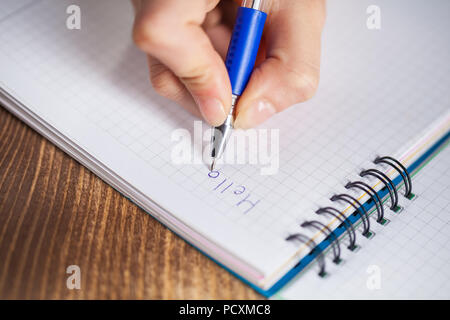 A chiudere la foto di una delle persone di scrivere una lettera con una penna. Foto Stock