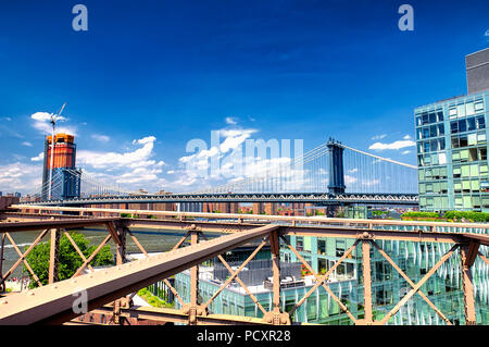 Un generico edificio moderno di Brooklyn con la Manhattan Bridge in background in una giornata di sole in New York City. Foto Stock