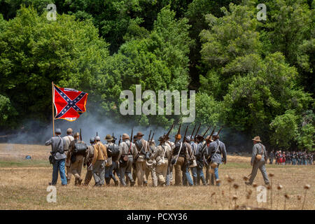 Duncan Mills, CA - Luglio 14, 2018: reenactors confederati in campo di battaglia durante una battaglia con la bandiera e la notevole fumo. Questa guerra civile Foto Stock