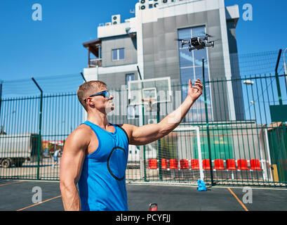 L'uomo lancia quadcopter Foto Stock