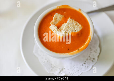 Minestra di pomodoro, Gazpacho nella ciotola bianco su bianco tovaglia sfondo, con ingredienti spazio Copia vista superiore Foto Stock