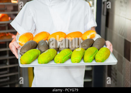 Il panettiere è azienda freschi panini multicolore in background del forno. Foto Stock