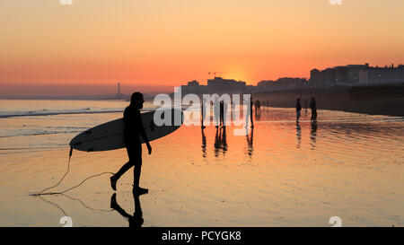 I riflessi del tramonto sulla spiaggia al tramonto, durante la bassa marea a Brighton Foto Stock