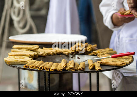 Venditore ambulante di cottura tacos fritti in un mercato messicano Foto Stock