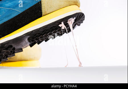 Scenario di simulazione della gomma da masticare sul pavimento, Stick con le scarpe da ginnastica. Foto Stock