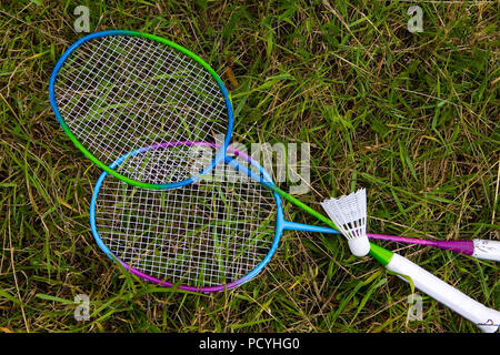 Per racchette da badminton e volano giacciono sull'erba. Attrezzature sportive. Foto Stock