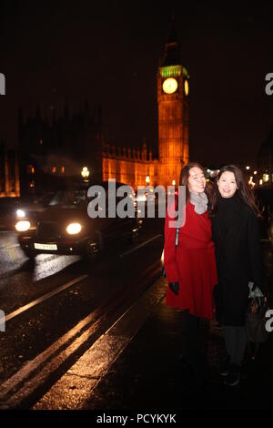 Due giovani studenti Korean ladies godere l'inverno sera durante la loro visita a Londra, foto sul Westminster Bridge con il Big Ben illuminata sullo sfondo Foto Stock