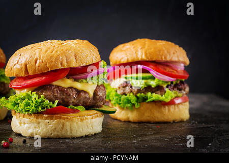 Hamburger di manzo hamburger di carne e verdure fresche su sfondo scuro. Il cibo gustoso. Foto Stock