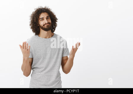 Ti ha detto che avevo ragione. Bello orientale modello maschio con la barba e capelli ricci, alzando le mani e smirking, essendo alleggerita e dire infine, in attesa fo Foto Stock