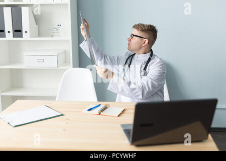 Ritratto di un giovane medico controllo immagine a raggi x in office Foto Stock