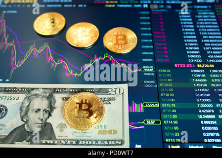 La carta bill venti Dollar, USD, sfondo sfocato. Il programma elettronico di bitcoin sullo scambio, volume trades, sul monitor si trovano monete d oro bitcoin. Foto Stock