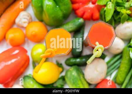 Un assortimento di frutta estiva fresca e verdure con due bicchieri di spremuta fresca o frullati in una vista dall'alto in basso pieno di sfondo del telaio Foto Stock