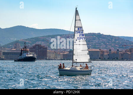 Trieste, Italia, il 4 agosto 2018. Una famiglia gode la loro barca a vela come towboat lascia il Mare Adriatico al porto di Trieste in Italia. Foto di Enrique Shore Foto Stock