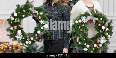 Produttore della ghirlanda di Natale da rami di pino per le vacanze. Master class sulla realizzazione di ornamenti decorativi. Decorazioni di Natale con le proprie mani. Festa del nuovo anno. Negozio di fiori Foto Stock