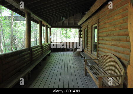 Grande portico su una capanna di legno nel mezzo del prato. Foto Stock
