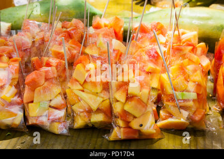 Papaia fresca frutta affettata in sacchetti di plastica al mercato di strada. Ceby city. Filippine. Foto Stock