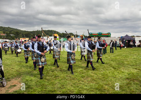 Stirling, Scozia, Regno Unito. 5 agosto 2018. Strathallan parco giochi vicino a Stirling è la sede per il 167° Bridge of Allan Highland Games. I membri della Royal Burgh di Stirling Pipe Band gioco tradizionale cornamusa scozzese e tamburi come essi marzo attraverso la showground. In competizioni come oggi indossano il loro numero 2 uniforme con lo Stirling e Bannockburn Caledonian società tartan. Giuseppe di credito Clemson, JY News Immagini/Alamy Live News. Foto Stock