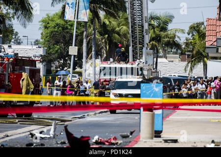 Santa Ana, CA, Stati Uniti d'America. 5 Ago, 2018. Curiosi di sostare dietro le linee della polizia e di guardare al relitto di un aereo Cessna e un veicolo danneggiato dall'urto in punti metallici parcheggio off Bristol St in Santa Ana CA. Un doppio motore Cessna si è schiantato SNA vicino Aeroporto John Wayne nel pomeriggio di domenica 5 agosto, 2018 nei punti metallici il parcheggio nel blocco 3000 di Bristol St in Santa Ana CA USA. Un PIO per la Contea di Orange Fire competente ha confermato ci sono stati 5 morti confermati a bordo del velivolo con nessun ferisce riportato sulla terra. Credito: Stuart Palley/ZUMA filo/Alamy Live News Foto Stock