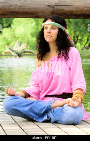 Fotografia di una bella donna hippie meditando sul fiume beach Foto Stock