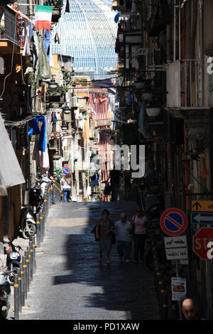 Tipica stradina in Napoli, Italia, con la cupola della Galleria Umberto I in background Foto Stock