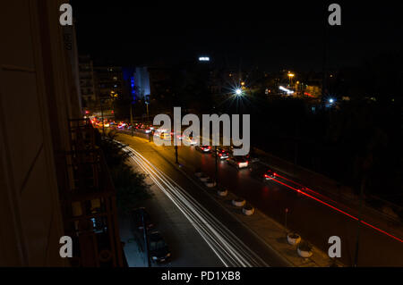 Fari di automobile le linee di formatura in una lunga esposizione Shot di notte ad Atene, Grecia Foto Stock