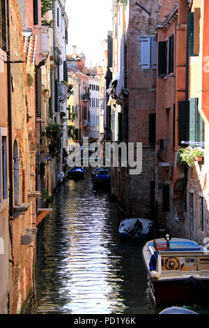 Barche ormeggiate al terrapieno di uno stretto canale a Venezia, Italia Foto Stock