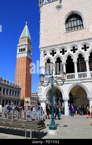Pila di passerelle pronto per il previsto "Acqua alta' a Venezia, Italia, con il Palazzo del Doge e il campanile in background Foto Stock
